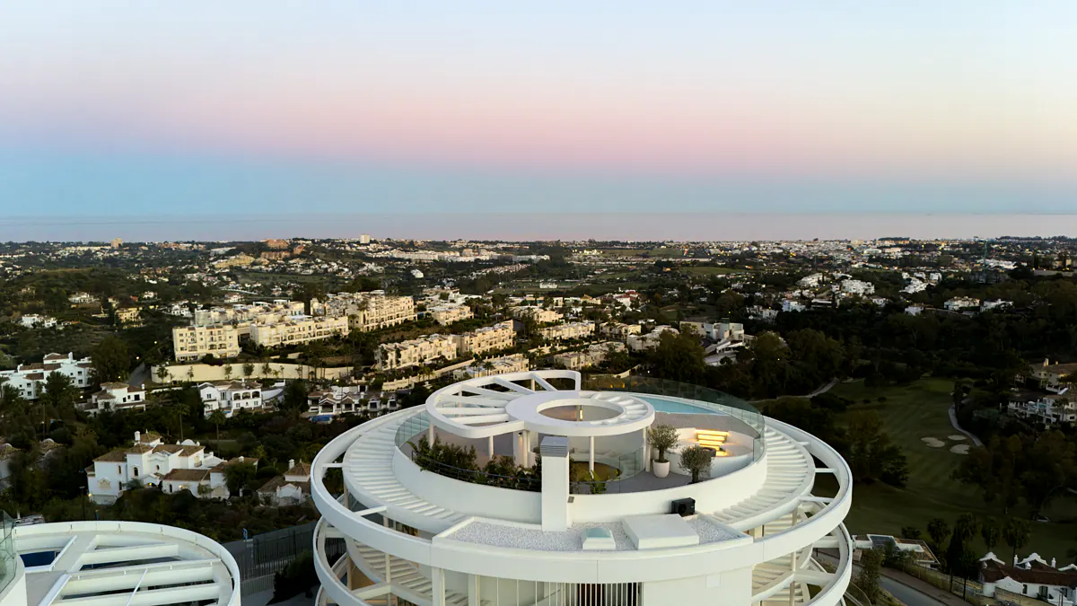 The roof of the circular building at dusk, with the sea behind
